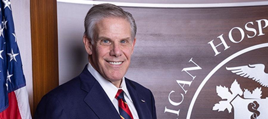 Rick Pollack, American Hospital Association CEO and President standing in front of United States flag and the AHA seal.